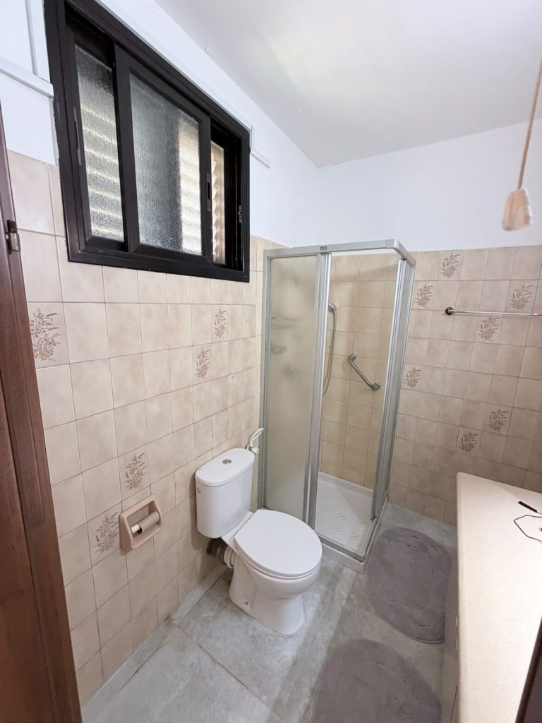 חדר אמבטיה לפני שיפוץ, אריחים ישנים ומקלחון מיושן